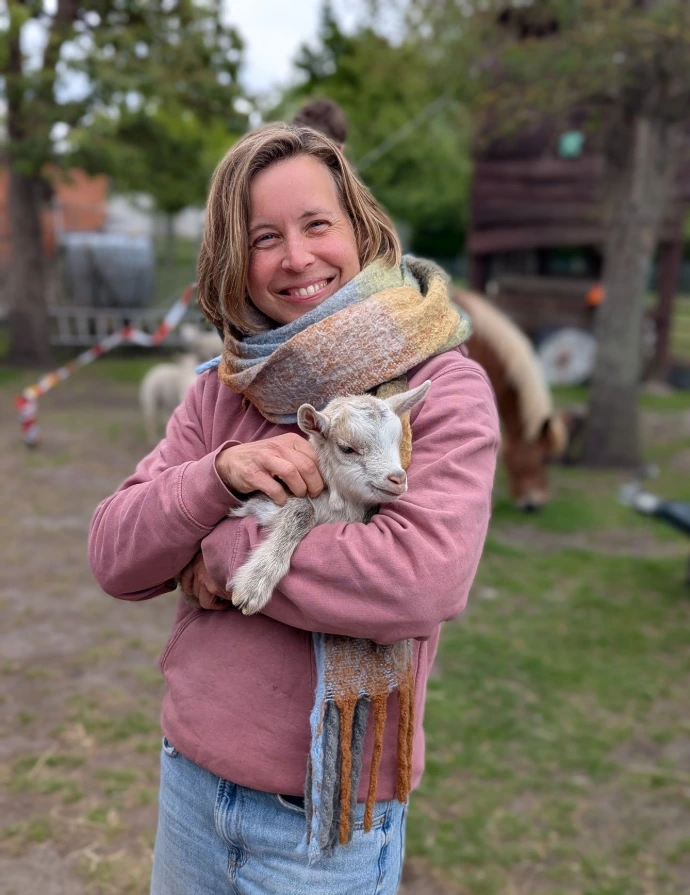 vrouw knuffelt geitje
