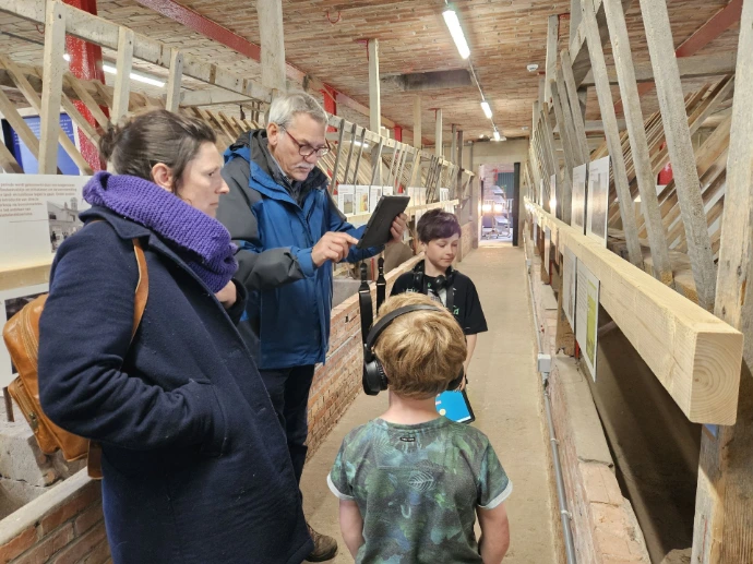 Een gezin gebruikt een tablet voor extra beleving op de expo.