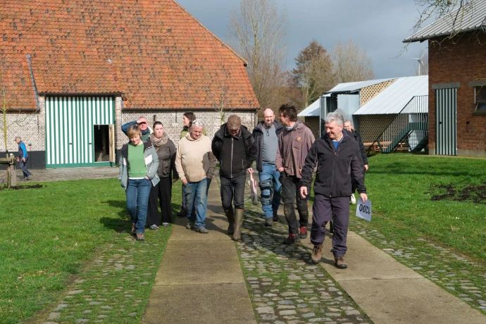 Groep bezoekers die belevingswandeling meevolgen met een vrijwilliger-gids