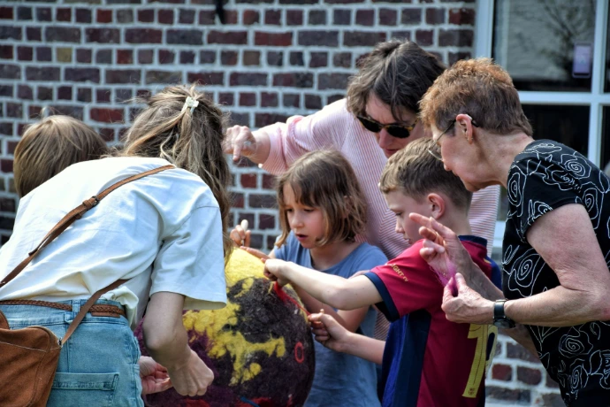 Kinderen aan het knutselen met volwassenen die hen helpen