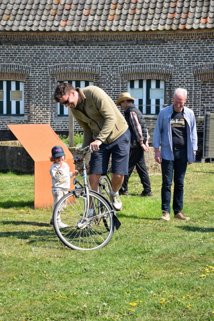 Man probeert zo lang mogelijk op stilstaande fiets te blijven zonder de grond te raken met zijn voeten