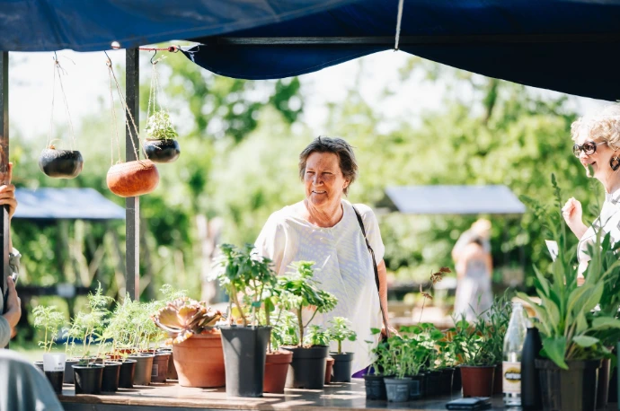 Vrouw aan een marktkraam met een lach