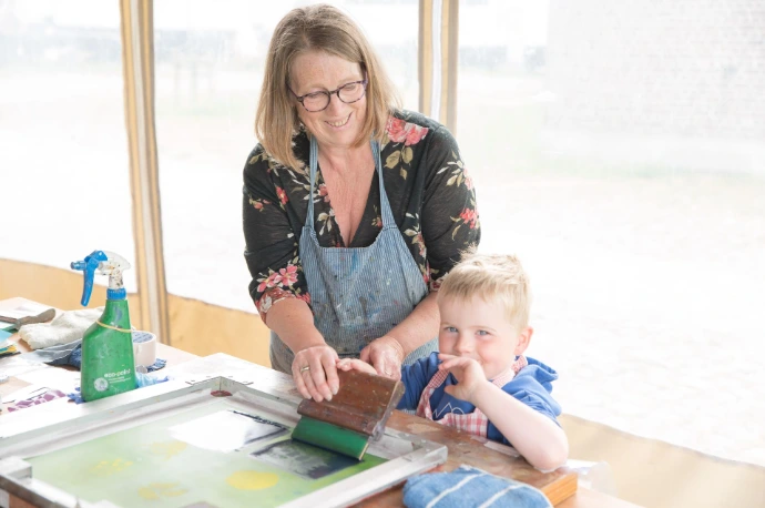 Vrijwilliger bedrukt textiel, samen met een kindje