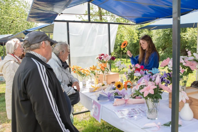 Marktkraam waar gehaakte bloemen te koop zijn.