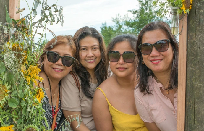 Bezoekers poseren in fotokader met bloemen