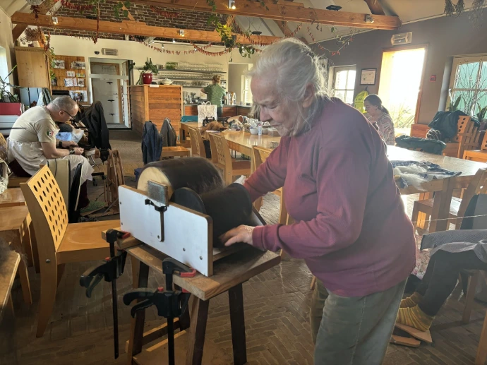 Een vrouw is wol aan het kammen