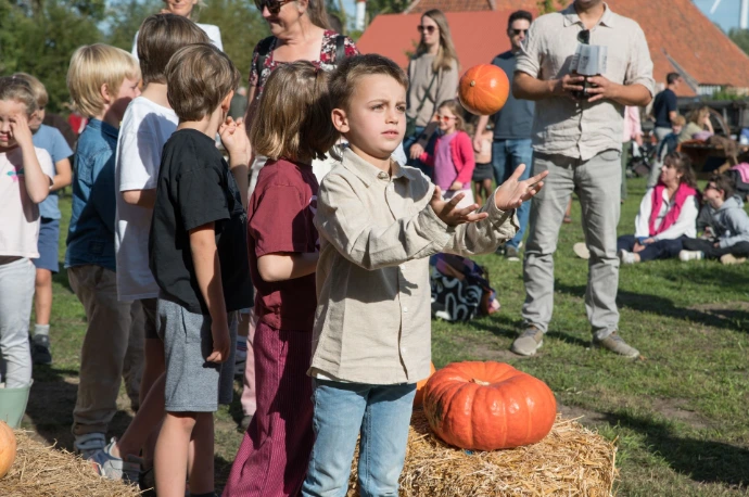 Kind gooit minipompoen in de lucht. Fotograaf: IsaDS Photography