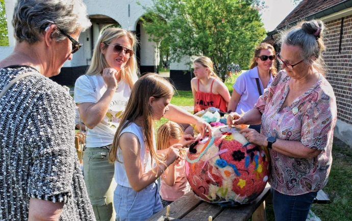 Vrijwilliger helpt bezoeker knutselen